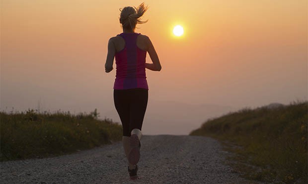 beautiful young woman runns cross country on a mountian path at